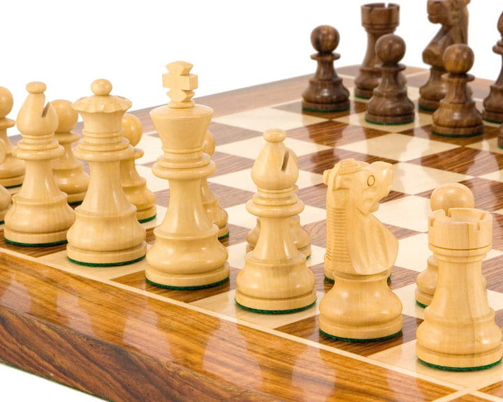 Golden rosewood and boxwood French Knight Staunton chess pieces on a wooden chessboard.