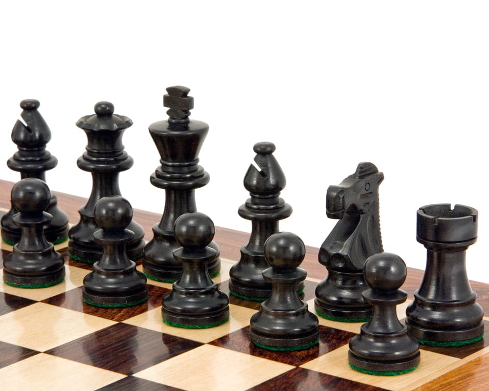 French Knight Series Ebonised Staunton Chess Pieces in classic black on a wooden chessboard, featuring a 3.25 inch king.