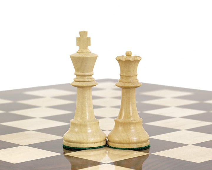 Boxwood king and queen chess pieces from the Conquest Series on a black-and-white chessboard.