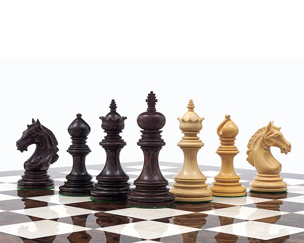 The Garvi 4 inch Rosewood Chessmen set featuring intricately carved pieces with billiard cloth bases on a chessboard