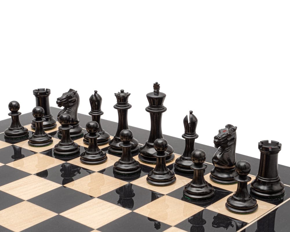 The Harrwitz Black and Antiqued Reproduction Chess Men 3.5 inch set with hand-carved boxwood pieces on a chessboard.