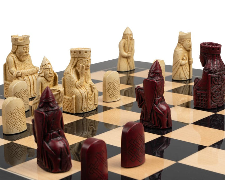 The Isle of Lewis black and red chess set with intricate red and cream chessmen pieces on a black and white chessboard.