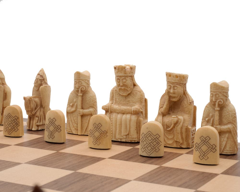 Isle of Lewis Chessmen on chessboard, intricately designed with crushed stone resin, featuring historical figures and symbols.